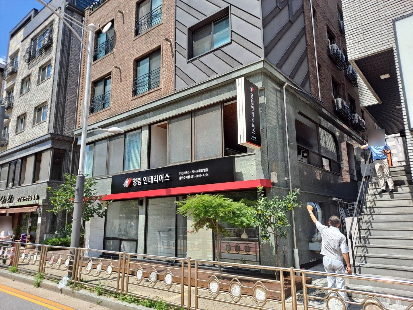 벽돌 건물 1층 모서리의 영림 인테리어스 간판과 세로 돌출간판